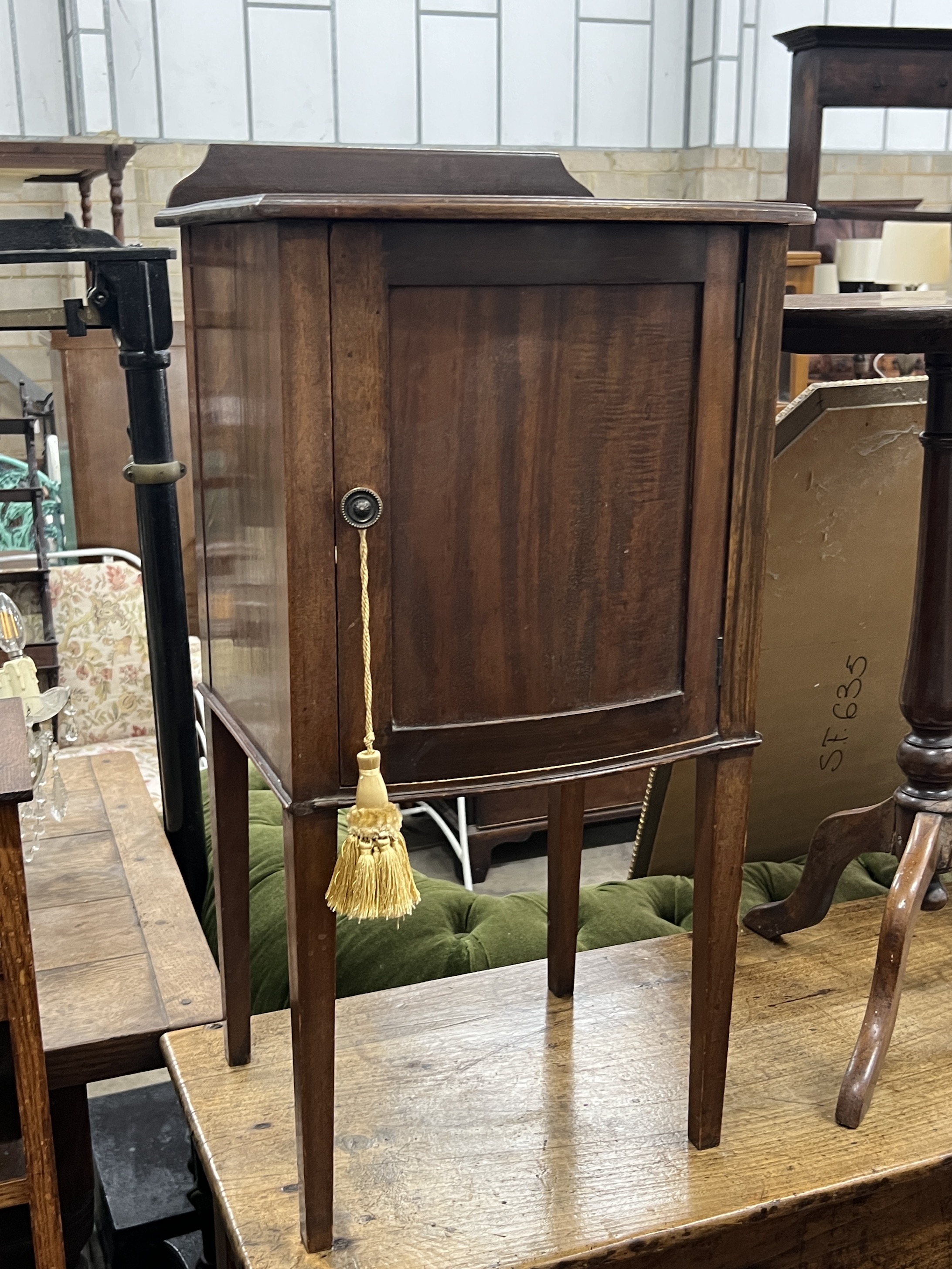 An Edwardian mahogany bow front bedside cabinet, width 40cm, height 82cm together with a Victorian circular wine table